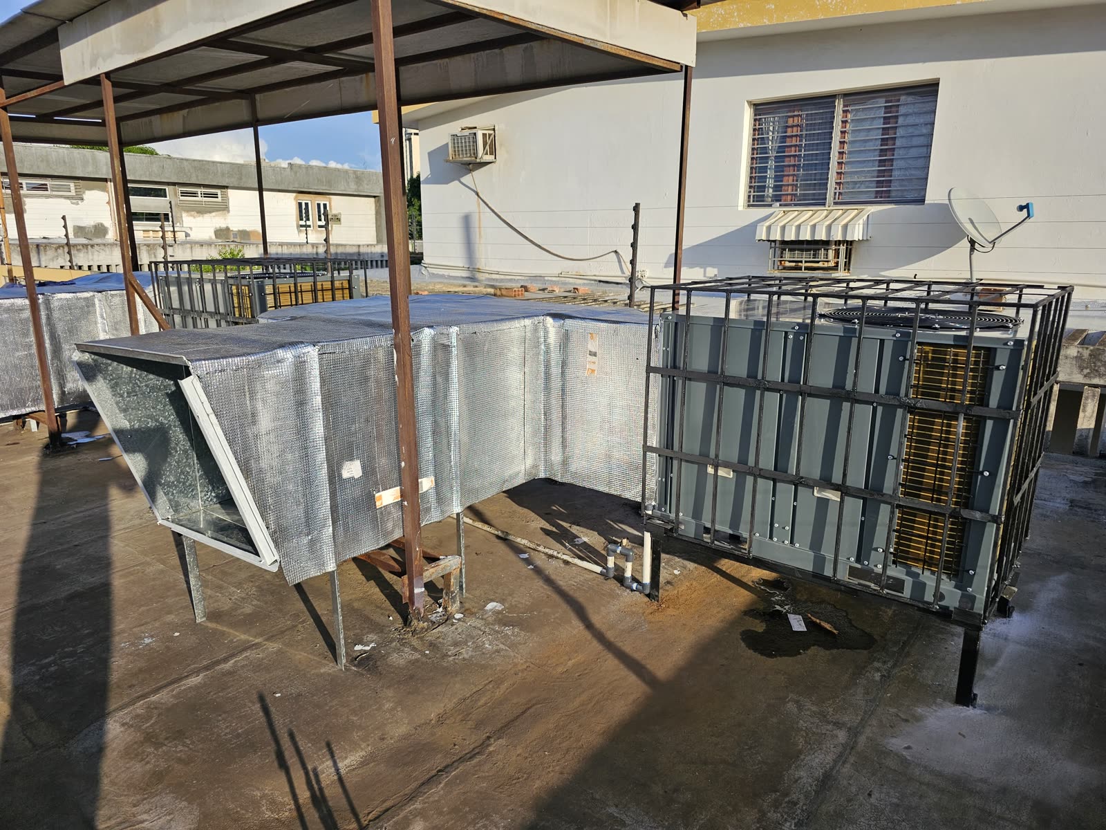 Unidad condensadora nueva instalada en jaula protectora con ductería aislada