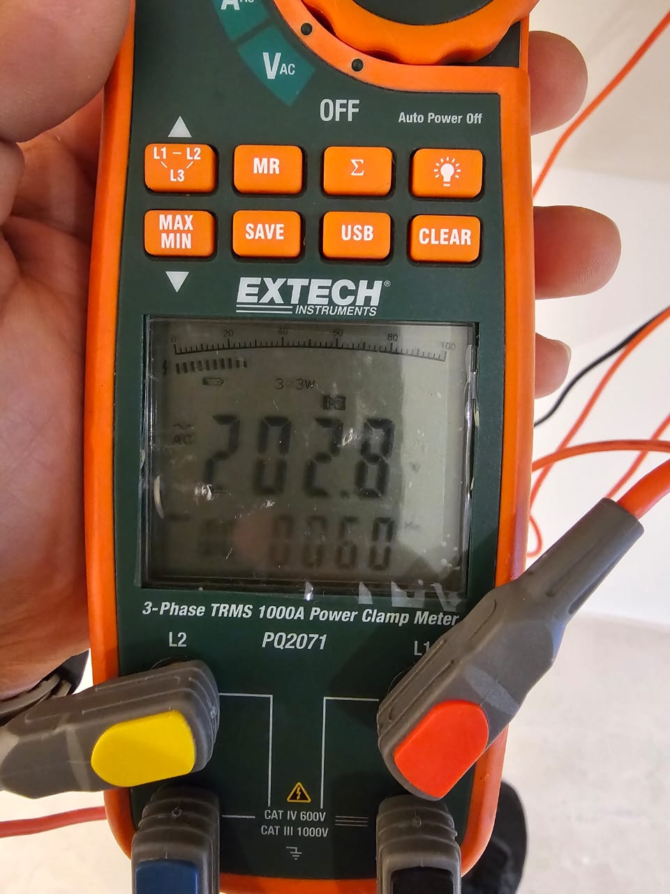 Pinza amperimétrica trifásica midiendo voltaje durante un diagnóstico