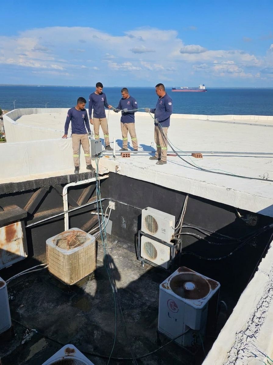 Equipo de técnicos de Enthalpy trabajando en una azotea frente al Lago de Maracaibo