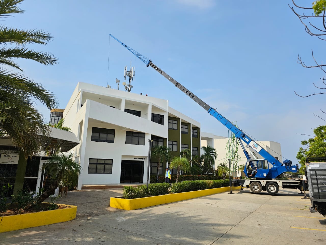 Grúa telescópica de 22 toneladas trabajando sobre edificio institucional