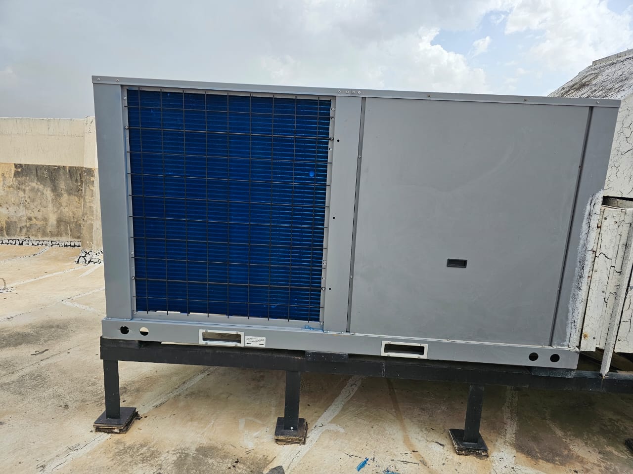 Unidad compacta de climatización recién instalada sobre estructura metálica